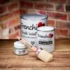 Frenchic Large Oval Brush with red ferrule displayed with Frenchic paint tins including Chalk Wall Paint, Lazy Range, and Al Fresco on wooden surface