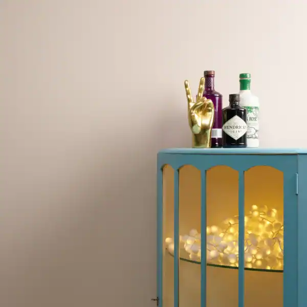 Decorative display at Stringers Home Decorating Centre featuring a blue cabinet with bottles and a gold hand sculpture.
