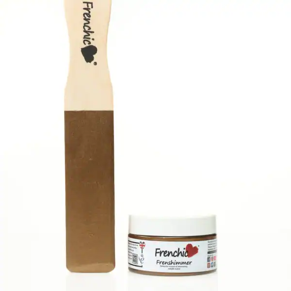 Close-up of a Frenchic Frenshimmer 100ml metallic powder jar and a wooden spatula with the Frenchic logo, used for furniture and decor projects.