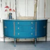 Elegant blue vintage sideboard with curved design and silver handles, ideal for home decorating and storage.