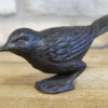 Cast iron bird sculpture with detailed feather texture, black finish, and perched stance, suitable for home decor or garden ornament.