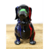 Colourful ceramic dog figurine with green, red, and blue accents on a wooden surface.