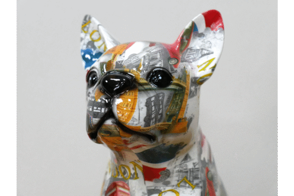 Decorative dog sculpture covered in colourful newspaper and magazine clippings, showcasing a modern art style.