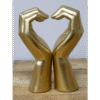 Decorative golden hand sculptures forming a heart shape, symbolising love and care.