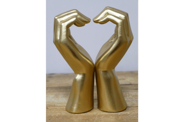 Decorative golden hand sculptures forming a heart shape, symbolising love and care.