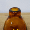 Small amber glass vase with a rounded top and narrow opening, perfect for decorative displays or small floral arrangements.