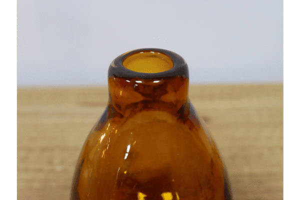 Small amber glass vase with a rounded top and narrow opening, perfect for decorative displays or small floral arrangements.