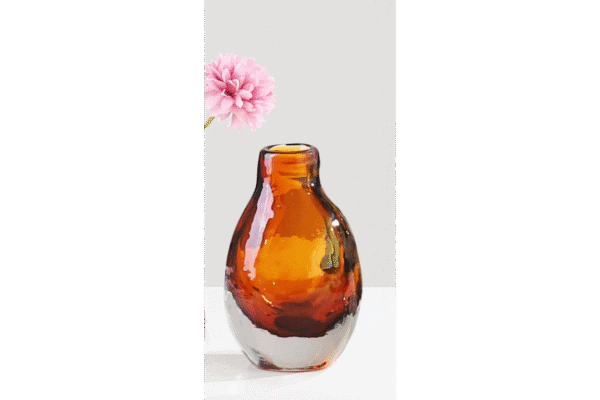 Small amber glass vase with a pink flower, perfect for home decorating and floral arrangements.