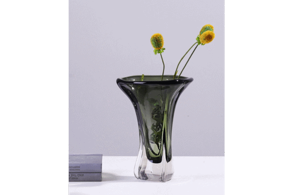 Elegant green glass vase with yellow and green flowers, ideal for home decorating and floral arrangements.
