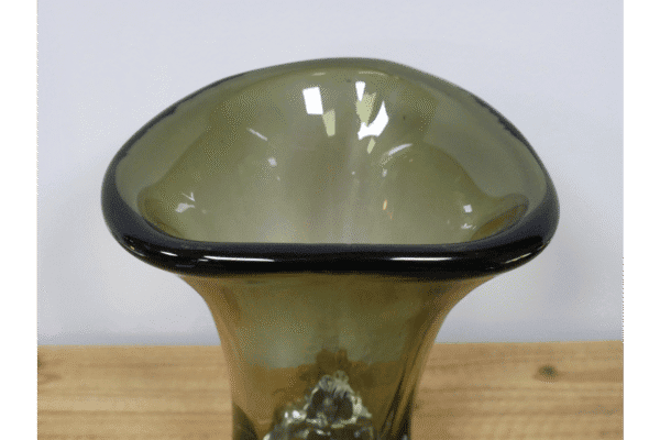 Green glass vase with a wide, rounded top and a narrow base, placed on a wooden surface.