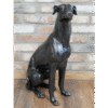 Decorative black dog sculpture sitting on a wooden floor against a brick wall at Stringers Home Decorating Centre.