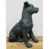 Bronze sculpture of a sitting dog with detailed features, placed on a wooden surface against a plain white background.