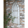 Arch rustic mirror with metal frame and decorative design, mounted on a brick wall in a home decor setting.