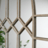 Close-up of a rustic wooden mirror frame with geometric diamond patterns, suitable for home decorating projects.
