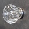 Close-up of a glass ribbed cabinet knob with a clear, textured design, mounted on a dark surface, ideal for home decorating projects.