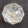 Close-up of a cut glass globe with intricate facets, used as a decorative cabinet knob or handle.
