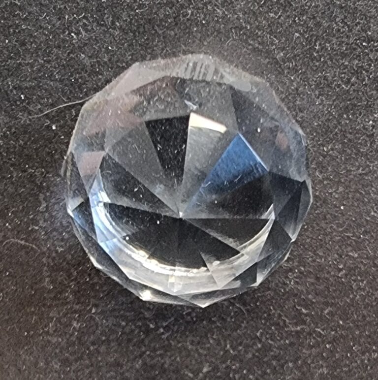 Close-up of a cut glass globe cabinet knob with faceted design, perfect for home decorating and furniture hardware.