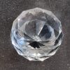 Close-up of a clear cut glass globe cabinet knob with intricate facets, perfect for enhancing furniture decor.
