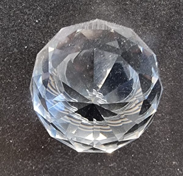 Close-up of a clear cut glass globe cabinet knob with intricate facets, perfect for enhancing furniture decor.