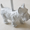 Decorative white metal dog door stop with a West Highland Terrier design, featuring a textured finish and a metal rod for stability.