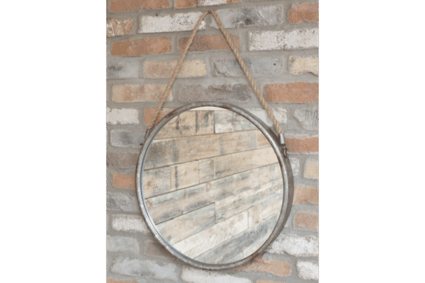 Industrial round mirror with metal frame and rope hanging on a brick wall, ideal for home decorating.