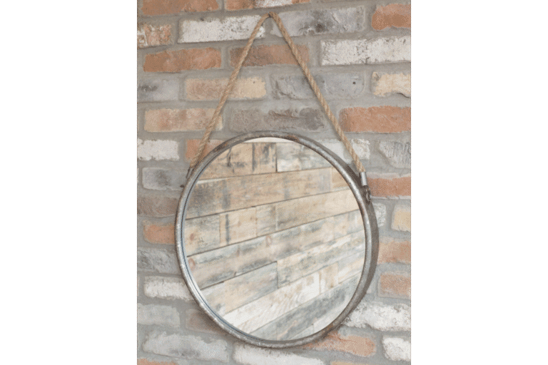 Industrial round mirror with metal frame and rope hanging on a brick wall, ideal for home decorating.
