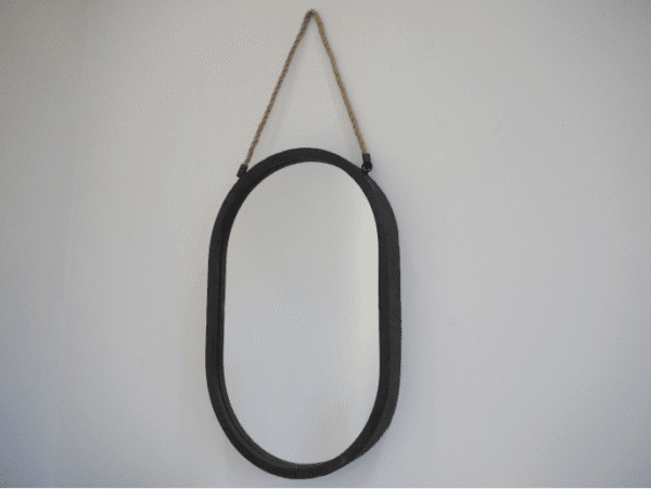 Black oval mirror with a rope hanger, suitable for modern home decor, displayed on a plain wall.