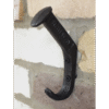 Close-up of a black railway pin coat hook mounted on a brick wall, used for hanging coats and accessories.