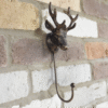Decorative metal stag hook mounted on a brick wall, ideal for home decor and hanging items.
