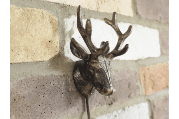 Decorative metal stag head wall hook with antlers, mounted on a brick wall, ideal for home decor and hanging items.