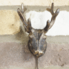 Decorative metal stag hook mounted on a brick wall, ideal for home decor and hanging items.