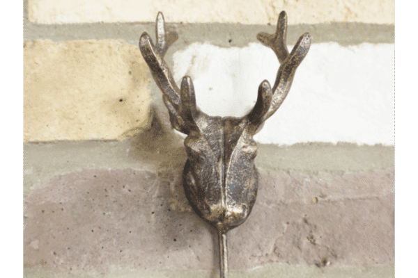 Decorative metal stag hook mounted on a brick wall, ideal for home decor and hanging items.