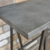 Close-up of an industrial-style console table with a concrete top and metal legs, suitable for modern home decor.