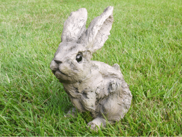 Wood effect bunny small sculpture on green grass, ideal for home decorating and garden decor.