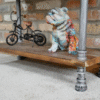 Industrial pipe shelf unit with a decorative bulldog figurine and a miniature bicycle, showcasing rustic and industrial decor style.