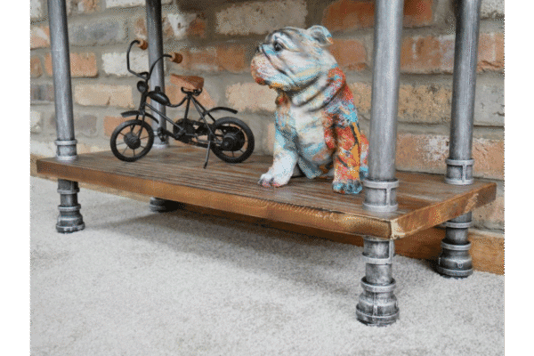 Industrial pipe shelf unit with a decorative bulldog figurine and a miniature bicycle, showcasing rustic and industrial decor style.
