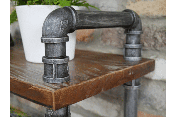 Industrial pipe shelf unit made from black metal pipes on a wooden surface, suitable for home decorating and storage solutions.