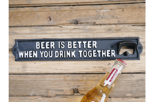 Wooden wall with a black sign reading 'Beer is better when you drink together' and a bottle opener attached.