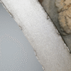 Close-up of a silver industrial round mirror with a textured metallic frame.