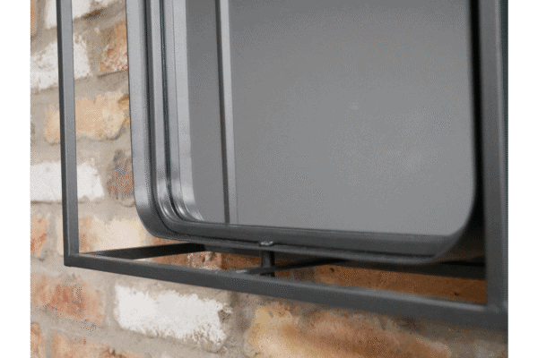 Close-up of a modern industrial wall unit with a mirror, mounted on a brick wall, showcasing sleek metal design and reflective surface.