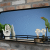 Decorative wall mirror with black frame, featuring potted plant, hand sculpture, and modern light bulbs on a black shelf against a brick wall.