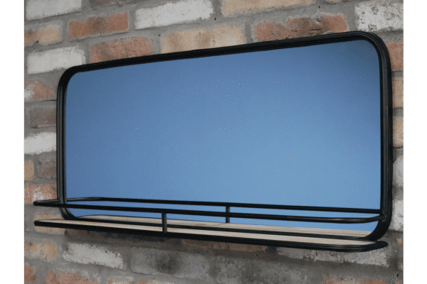 Modern black mirror with shelf mounted on a brick wall, ideal for home decor and storage solutions.