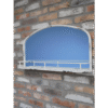 A vintage aged white mirror with a built-in shelf, mounted on a brick wall, ideal for home decor and wall accents.