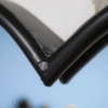 Close-up of a black metal heart-shaped mirror with a rope border, highlighting the corner detail.
