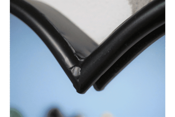 Close-up of a black metal heart-shaped mirror with a rope border, highlighting the corner detail.