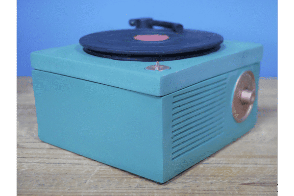 Vintage gramophone storage box with a turntable on top, in turquoise colour, on a wooden surface.