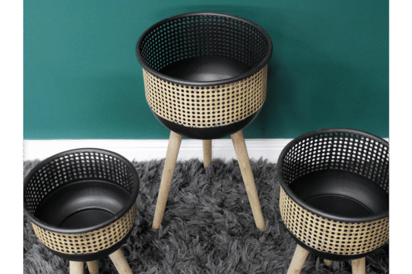 Set of three modern plant planters with wooden legs and black perforated design, suitable for indoor or outdoor decor.