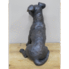 Gunmetal metallic sitting dog sculpture with a textured finish on a wooden surface.
