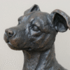 Gunmetal metallic sitting dog sculpture with detailed features and realistic appearance.