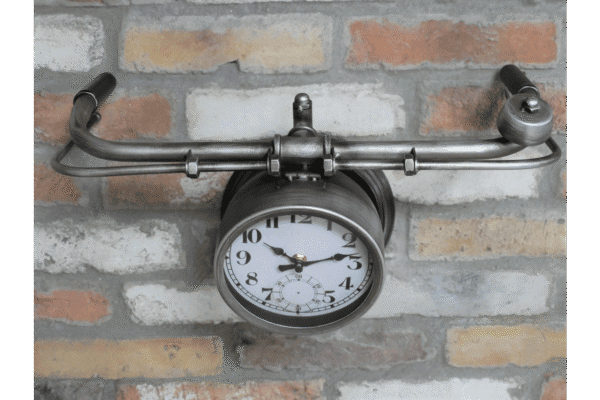 Handlebar bike clock mounted on a brick wall, combining vintage bicycle parts with a functional timepiece.